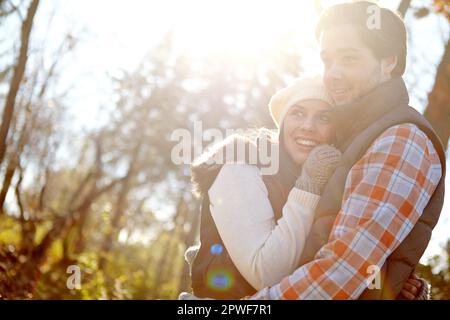 Sich im Herbst verlieben. Ein liebevolles junges Paar, das sich draußen umarmt. Stockfoto