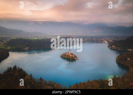 Blick auf den Sonnenuntergang oder Sonnenaufgang im Herbst über der malerischen Inselkapelle des Bleder Sees, Slowenien. Stockfoto