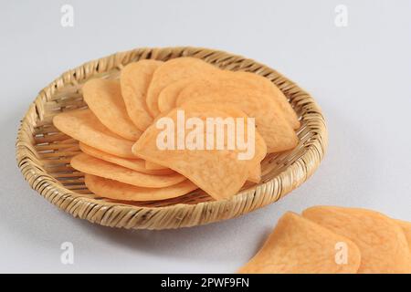 Kerupuk Udang Mentah oder rohe Garnelen-Cracker auf Bambus Rattan-Teller auf dem weißen Tisch Stockfoto