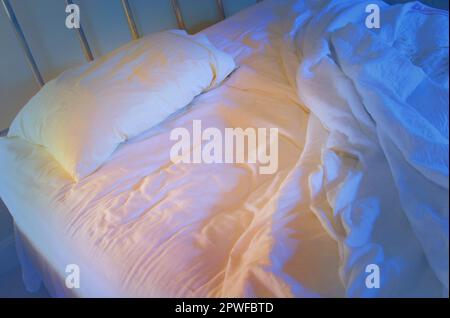 Nicht gemachtes einsames Bett. Stockfoto