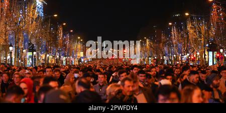 Paris, Frankreich - 1. Januar 2023 : auf der Champs Elysées in Paris versammelten sich viele Menschen, um den Übergang zur 2023 um Mitternacht zu feiern Stockfoto