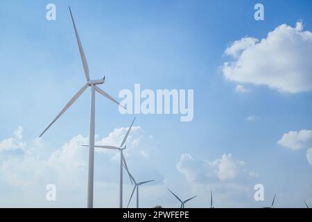 Windmühlen-Industriefarm mit Wolken und blauem Himmel, Windturbinenfeld Stockfoto