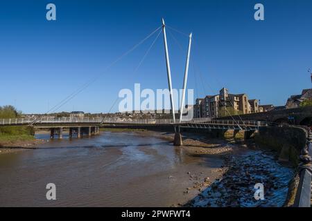 19.04.023 Lancaster, Lancashire, Vereinigtes Königreich. Die Lune Millennium Bridge ist eine Fußgängerbrücke mit Kabelhalterungen, die sich über den Fluss Lune in Lancaster, England erstreckt. Stockfoto