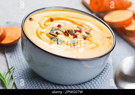 Süße Kartoffelsuppe, leckerer hausgemachter Kürbis, Süßkartoffel, Karottensuppe in einer Schüssel auf hellem Hintergrund Stockfoto
