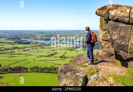 Ein Mann mit Blick über das Tittesworth Reservoir, der mit dem Rucksack auf dem Hen Cloud Ridge im Peak District Stafordshire Moorlands liegt Stockfoto