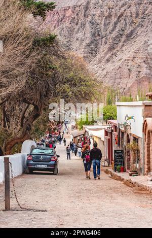 Purmamarca, Jujuy, Argentinien - September 2019: Touristen, die die Straßen von Purmamarca entlang laufen Stockfoto