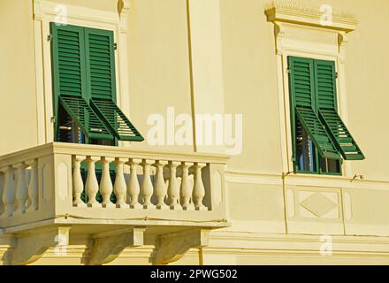 Ein Teil der Fassade eines Hauses mit Balkon und zwei Fenstern Stockfoto