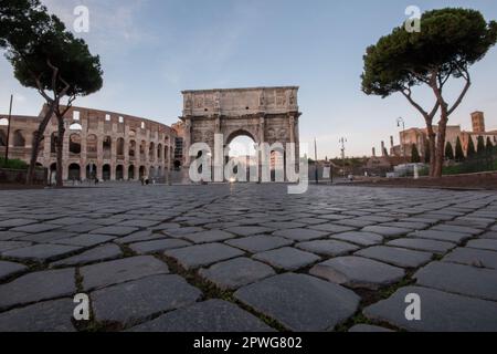 Rom, Italien - Blick auf das Kolosseum bei Sonnenaufgang, mit Schwerpunkt auf dem traditionellen Kopfsteinpflaster Stockfoto