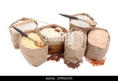 Papierbeutel mit verschiedenen Mehlsorten auf weißem Hintergrund Stockfoto