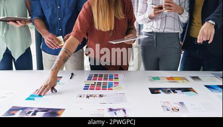Sicherstellen, dass ihre Vision zum Erfolg führt. Nahaufnahme einer Gruppe von Designern, die gemeinsam in einem Büro die Papiere durchgehen. Stockfoto