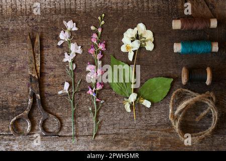 Flache Liegezusammensetzung mit schönen getrockneten Blumen auf Holztisch Stockfoto