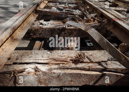 Selektiver Fokus und Details des Abbruchs von rustikalen Bahngleisen auf alten Eisenbahnschwellen aus recyceltem Holz. Stockfoto