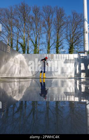 26. April 2023, Bayern, Nürnberg: Michael, Schichtleiter und Poolwächter im Stadionbad, entfernt wetterbedingte Verschmutzungen wie Algen oder Blätter während der Reinigungsarbeiten aus dem leeren Tauchbecken im Stadionbad, um sich auf die Outdoor-Poolsaison 2023 vorzubereiten. Je nach Wetterlage werden die ersten Außenpools voraussichtlich Anfang Mai eröffnet, andere folgen nach Angaben mehrerer bayerischer Städte und kommunaler Poolbetreiber Mitte des Monats. Die Eintrittspreise bleiben an vielen Stellen stabil, aber viele Poolbetreiber beschweren sich über Personalmangel Stockfoto