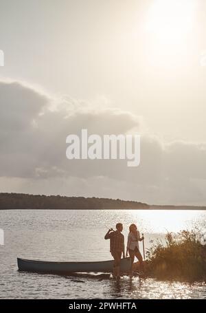 Ein bisschen Romantik, ein bisschen Entspannung. Ein junges Paar, das eine Kanufahrt auf dem See macht. Stockfoto