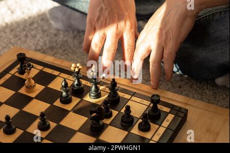 Schachspiel und Männerhände in der Nähe des Schachbretts, das Konzept des Spiels Stockfoto