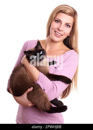 junge Frau, die siamesische Katze im Arm halten Stockfoto