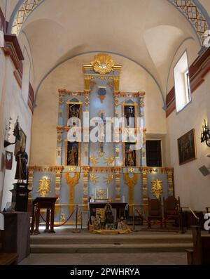 Verzierte blaue und goldene Reredos oder dekorative Leinwand mit Nischen für religiöse Statuen an der Wand hinter dem Altar in der Mission Concepcion in San Anto Stockfoto