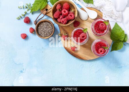 Chiasamen-Pudding mit Himbeere und Marmelade oder Smoothies mit Chiasamen auf einem Steintisch. Gesundes Frühstück. Blick von oben. Speicherplatz kopieren. Stockfoto