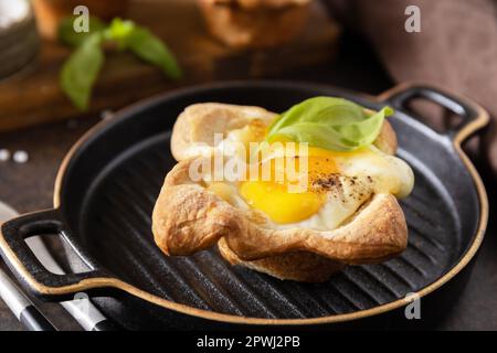 Rührei in Blätterteig mit Käse und Speck auf einem Steinteller. Frühstücksidee, Snacks. Stockfoto