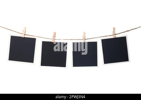 Kleiderschränke mit leeren Sofortrahmen auf einer Schnur vor weißem Hintergrund. Platz für Text Stockfoto