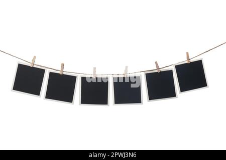 Kleiderschränke mit leeren Sofortrahmen auf einer Schnur vor weißem Hintergrund. Platz für Text Stockfoto