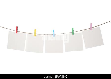 Kleidung mit leeren Notizbüchern auf Schnur vor weißem Hintergrund. Platz für Text Stockfoto
