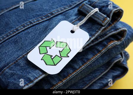 Gefaltete Jeans mit Recycling-Etikett, Nahaufnahme Stockfoto