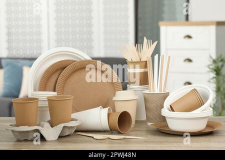 Set aus umweltfreundlichen Einweg-Geschirr auf Holztisch im Innenbereich Stockfoto