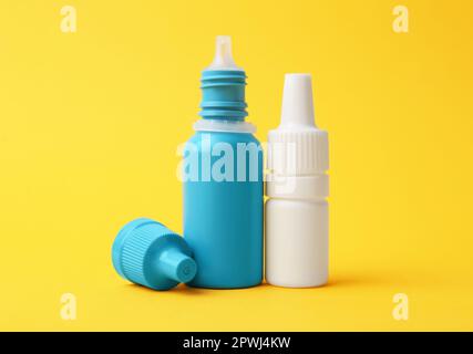 Flaschen medizinischer Tropfen auf gelbem Hintergrund Stockfoto
