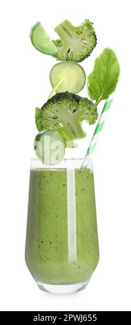 Frisches Gemüse, das in Glas fällt, mit leckerem Smoothie auf weißem Hintergrund Stockfoto