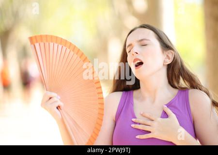 Eine Frau, die an einem heißen Sommertag im Park Stress macht Stockfoto