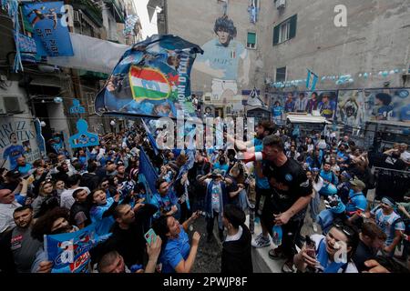 Neapel, Italien. 30. April 2023. Fans jubeln neben einem Wandgemälde, auf dem Diego Armando Maradona abgebildet ist und auf das Ergebnis des Fußballspiels SSC Napoli gegen US Salernitana wartet. Nach SS Lazios Niederlage gegen den FC Inter konnte Neapel heute die italienische Fußballmeisterschaft der Serie A gewinnen. Kredit: Unabhängige Fotoagentur/Alamy Live News Stockfoto