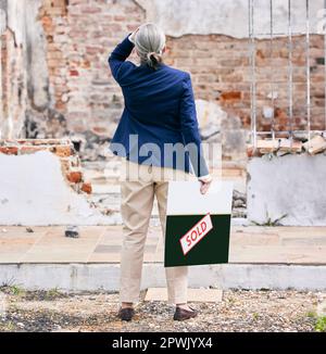 Tränen sind die stille Sprache der Trauer. Eine Immobilie, die vor einem abgebrannten Grundstück steht Stockfoto