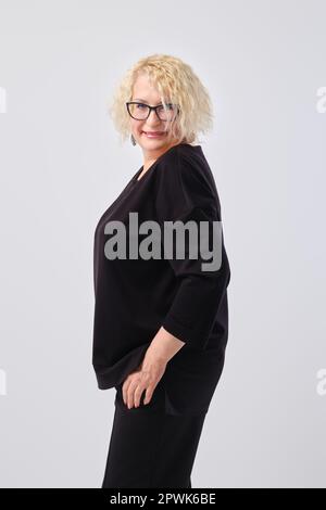 Porträt einer lächelnden Frau mittleren Alters mit kurzen blonden Locken im Profil Stockfoto