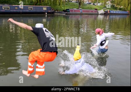 Jesus Green, Cambridge, 30. April 2023 Studenten der Universität Cambridge tauchen am Sonntagnachmittag in der Sonne der Bank Holiday in den Fluss Cam für die jährliche Trinkparty „Caesarian Sunday“ ein. Studenten der angesehenen Institution haben den Nachmittag in schicken Kleidern durchgemacht und an Trinkspielen auf Jesus Green teilgenommen. Die Tradition, auch bekannt als „C-Sonntag“, zieht Tausende von Studenten an, kurz bevor sie an Prüfungen teilnehmen. Die Polizei war anwesend, um die Akademiker in Schach zu halten. Quelle: Stop Press Media/Alamy Live News Stockfoto