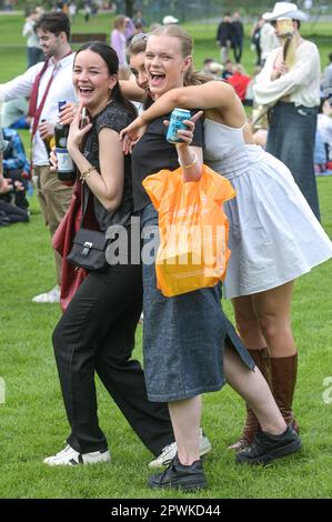 Jesus Green, Cambridge, 30. April 2023 - Horden von Studenten der Cambridge University strömten am Sonntagnachmittag in den Park, um an Feiertagen die alljährliche „Caesarian Sunday“-Trinkparty zu feiern. Studenten der renommierten Institutionen haben den Nachmittag in schicken Kleidern verbracht und an Trinkspielen auf Jesus Green teilgenommen. Die Tradition, auch bekannt als „C-Sunday“, zieht Tausende von Studenten kurz vor der Teilnahme an den Prüfungen an. Die Polizei war anwesend, um die Akademiker in Schach zu halten. Kredit: Ben Formby/Alamy Live News Stockfoto