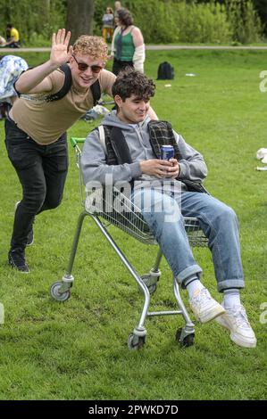 Jesus Green, Cambridge, 30. April 2023 - am Sonntagnachmittag strömten Horden von Studenten der Universität Cambridge in einen Park, um die jährliche „Caesarian Sunday“-Trinkparty zu veranstalten. Studenten der renommierten Institutionen haben den Nachmittag in schicken Kleidern durchgemacht und an Trinkspielen auf Jesus Green teilgenommen. Die Tradition, auch bekannt als „C-Sonntag“, zieht Tausende von Studenten an, kurz bevor sie an Prüfungen teilnehmen. Die Polizei war anwesend, um die Akademiker in Schach zu halten. Einige Nachtschwärmer brauchen Hilfe von Sanitätern nach verschiedenen Missgeschicken. Quelle: Stopp Drücken Sie Mich Stockfoto