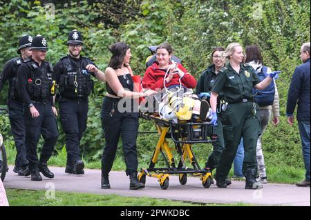 Jesus Green, Cambridge, 30. April 2023 Ein Student wurde von Sanitätern und Polizisten besucht, nachdem er von einem Baum gefallen war, als Horden von Studenten der Universität Cambridge am Sonntagnachmittag in einen Park strömten, um die jährliche „Caesarian Sunday“-Trinkparty zu feiern. Studenten der angesehenen Institution haben den Nachmittag in schicken Kleidern durchgemacht und an Trinkspielen auf Jesus Green teilgenommen. Die Tradition, auch bekannt als „C-Sonntag“, zieht Tausende von Studenten an, kurz bevor sie an Prüfungen teilnehmen. Die Polizei war anwesend, um die Akademiker in Schach zu halten. Guthaben: Stopp Stockfoto