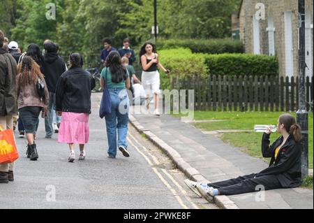 Jesus Green, Cambridge, 30. April 2023 - am Sonntagnachmittag strömten Horden von Studenten der Universität Cambridge in einen Park, um die jährliche „Caesarian Sunday“-Trinkparty zu veranstalten. Studenten der angesehenen Institution haben den Nachmittag in schicken Kleidern durchgemacht und an Trinkspielen auf Jesus Green teilgenommen. Die Tradition, auch bekannt als „C-Sonntag“, zieht Tausende von Studenten an, kurz bevor sie an Prüfungen teilnehmen. Die Polizei war anwesend, um die Akademiker in Schach zu halten. Quelle: Stop Press Media/Alamy Live News Stockfoto