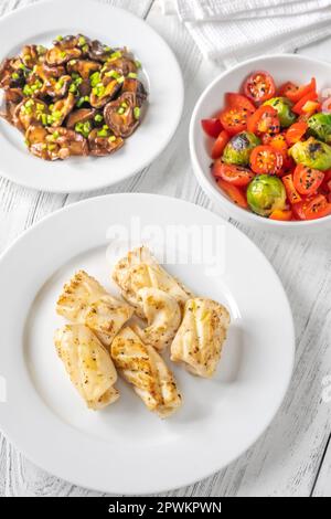 Portion gebratener Calamari mit Shiitake-Pilzen und Tomatensalat Stockfoto