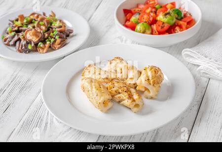 Portion gebratener Calamari mit Shiitake-Pilzen und Tomatensalat Stockfoto
