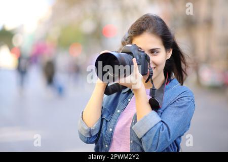 Glücklicher Fotograf, der Fotos mit der dslr-Kamera auf der Straße macht Stockfoto