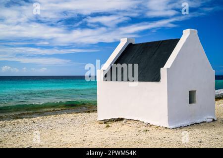 Ein Blick auf die Sklavenhäuser auf Bonaire in der Karibik mit blauem Himmel und türkisfarbenem Meer Stockfoto