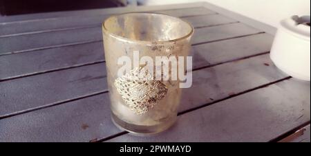 Glasbecher mit goldenem kunstvollem Muster. Wunderschöne Ornamente im orientalischen Stil auf den Gerichten. Eine Schüssel oder Tasse auf einem grauen Planktisch. Dekorationsgeschirr und in Stockfoto