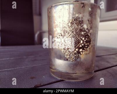 Glasbecher mit goldenem kunstvollem Muster. Wunderschöne Ornamente im orientalischen Stil auf den Gerichten. Eine Schüssel oder Tasse auf einem grauen Planktisch. Dekorationsgeschirr und in Stockfoto