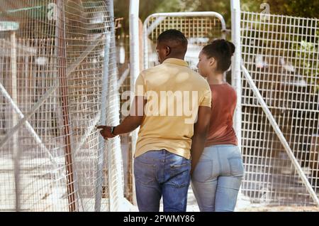 Schwarzes Paar, Tierheim oder Zoo, die zusammen spazieren und über Auswahl, Wohltätigkeitsarbeit und ehrenamtliche Arbeit auf Reisen in Südafrika sprechen. Mann und Frau Stockfoto