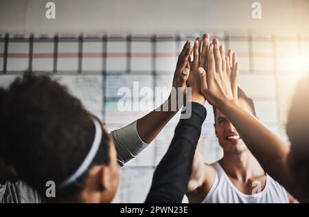 Fitness- und Freundschaftsziele erreicht. Eine Gruppe junger Leute, die sich gegenseitig während ihres Trainings in einem Fitnessstudio einen High Five geben Stockfoto