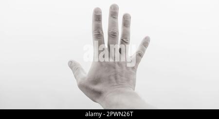 Die Hand eines Mannes zeigt fünf Finger im Nebel. Mystisches Konzept Stockfoto