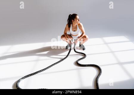 Junge Sportlerinnen trainieren in einem Sportstudio mit Sportgeräten. Fit trainieren. Konzept über Fitness, Wellness und Sportvorbereitung. Stockfoto