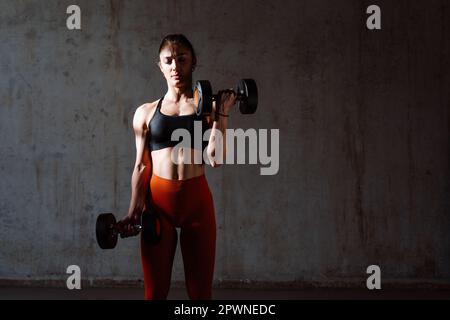 Junge Sportlerinnen trainieren in einem Sportstudio mit Sportgeräten. Fit trainieren. Konzept über Fitness, Wellness und Sportvorbereitung. Stockfoto